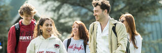 A group of Saint Joseph's University student walking campus on a sunny day.