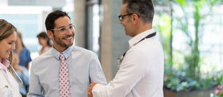 A health administrator talks with two doctors