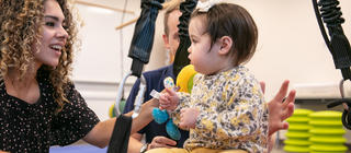 An occupational therapist works with a small child on balance
