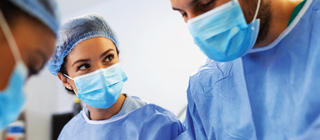 A nurse assists with a procedure in a light operating room