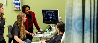 A sonography student uses an ultrasound machine in a simulated exercise