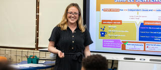 Educator at front of classroom giving a lesson on grammar