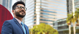 Man in a suit walks downtown among tall buildings