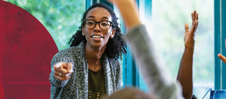 A teacher calls on a student with their hand raised