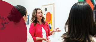 Museum educator teaching group of students in Maguire Museum at Saint Joseph's University