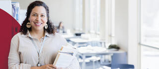 Educator smiles while holding books
