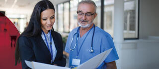 A doctor and a hospital administrator in hospital review documents