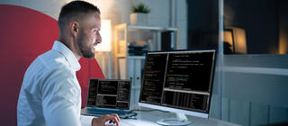 A computer programmer writes code in an office