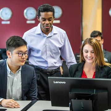 Computer science students working on a computer together