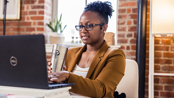 A Saint Joe's graduate student studies on their laptop at home
