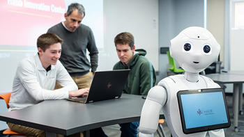 AI robot with a tablet and 2 students and a professor behind it
