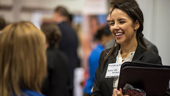 A female student talks to a recruiter at the annual career fair on campus